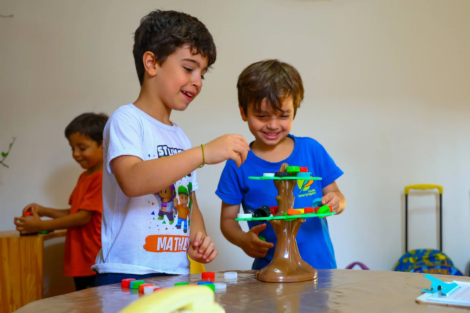 Duas crianças brincam juntas com uma construção sobre a mesa.