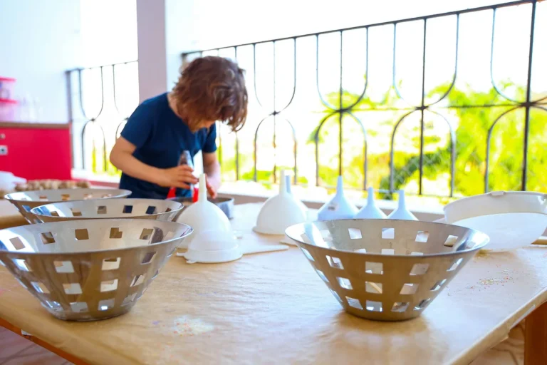 Mesa com cestos, recipientes e utensílios ao alcance de uma criança na Escola Sabiá-Laranjeira.