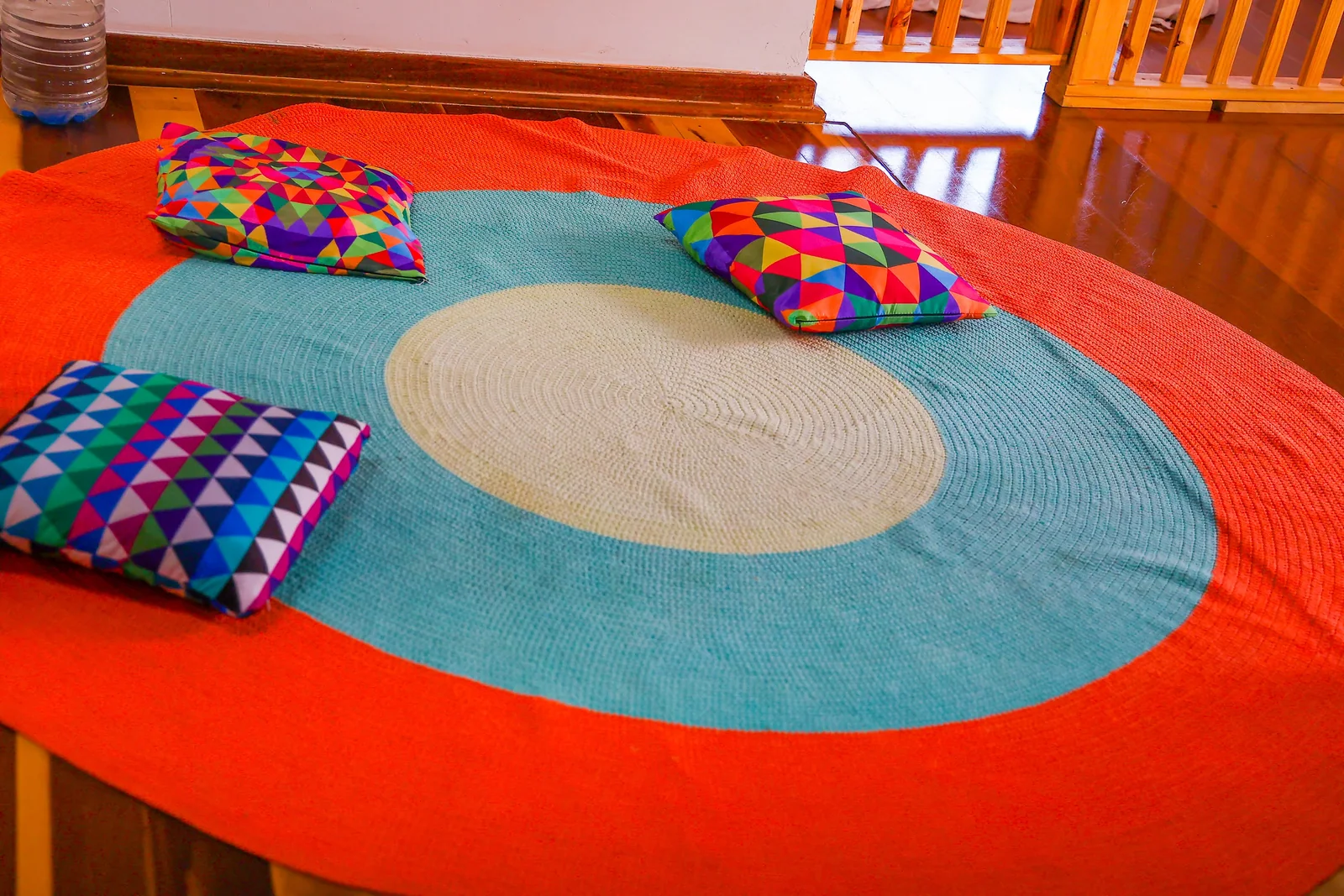 Tapete circular e almofadas coloridas em um ambiente da escola.