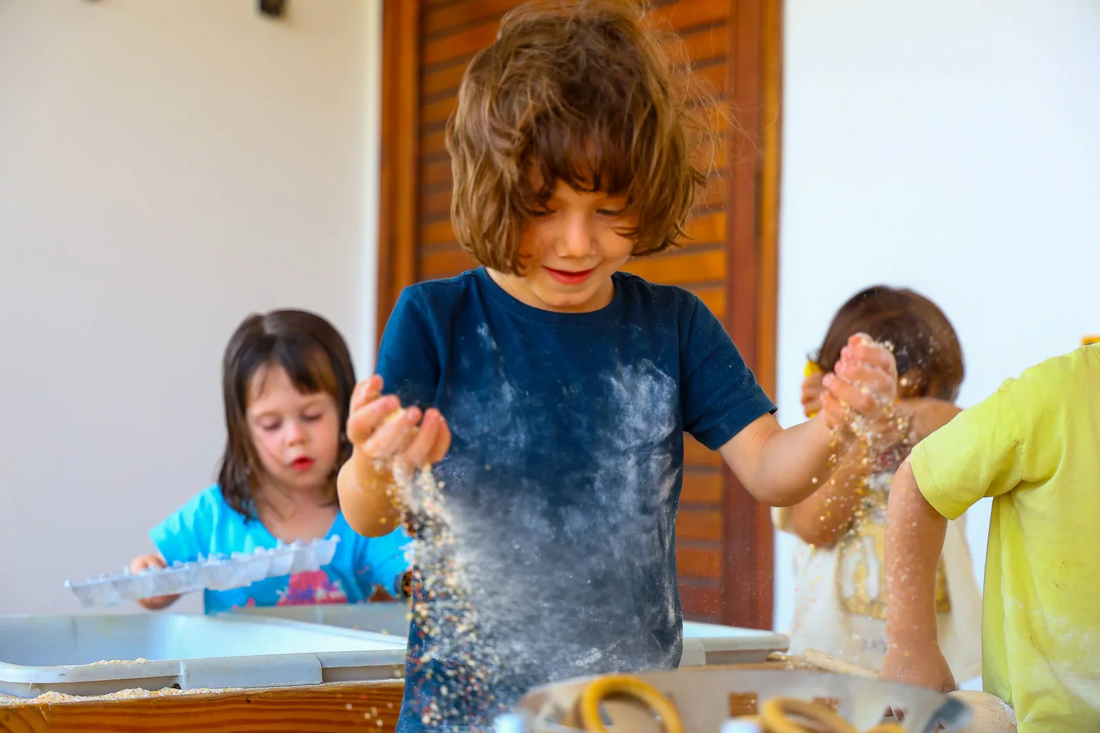Criança observa e explora materiais com as mãos.