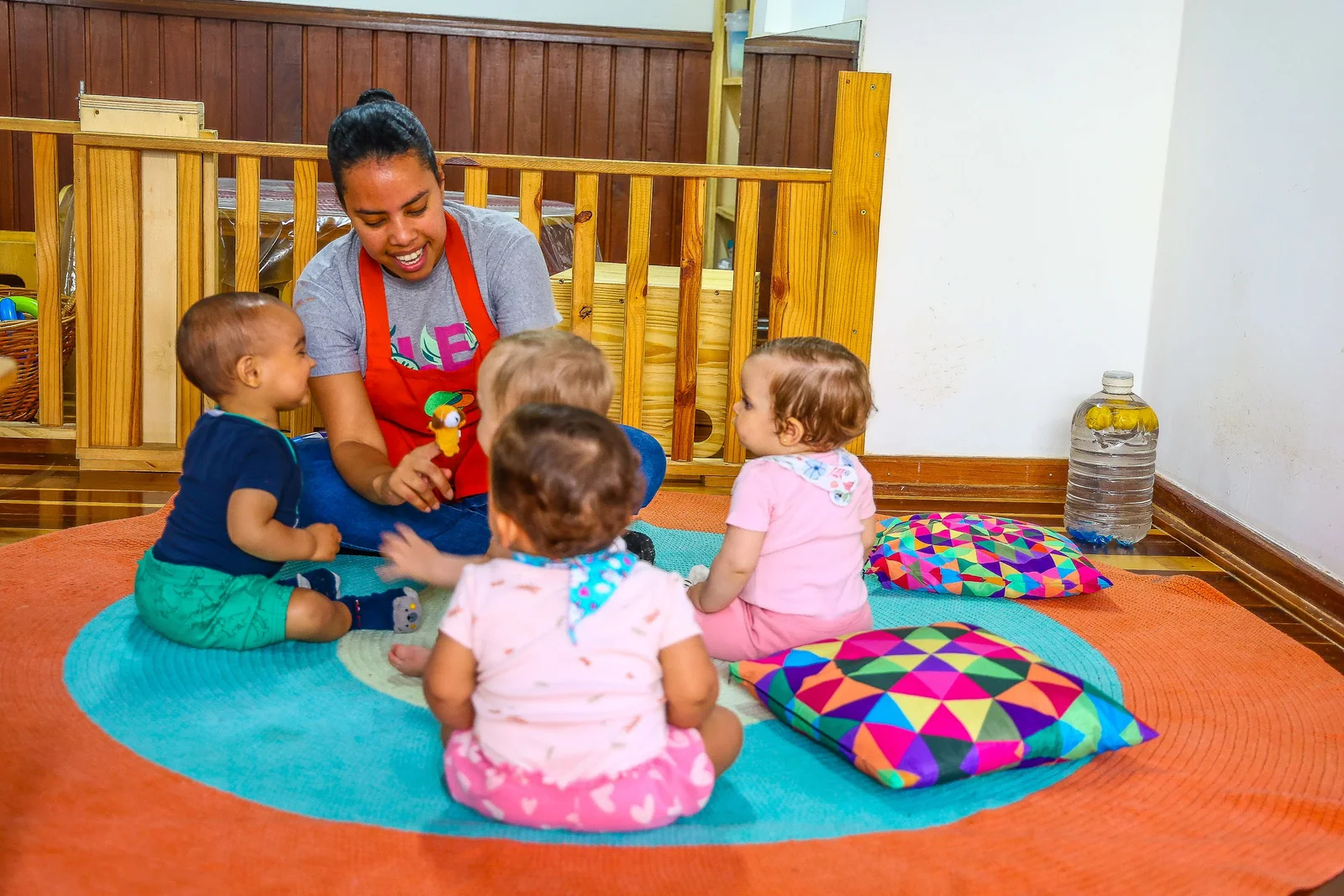 Educadora lê um livro com um grupo de crianças na Escola Sabiá-Laranjeira.